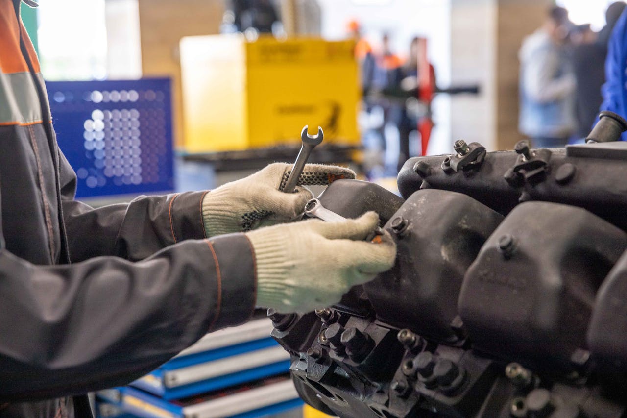 Close-up of a mechanics hands working on an engine in a modern workshop.
